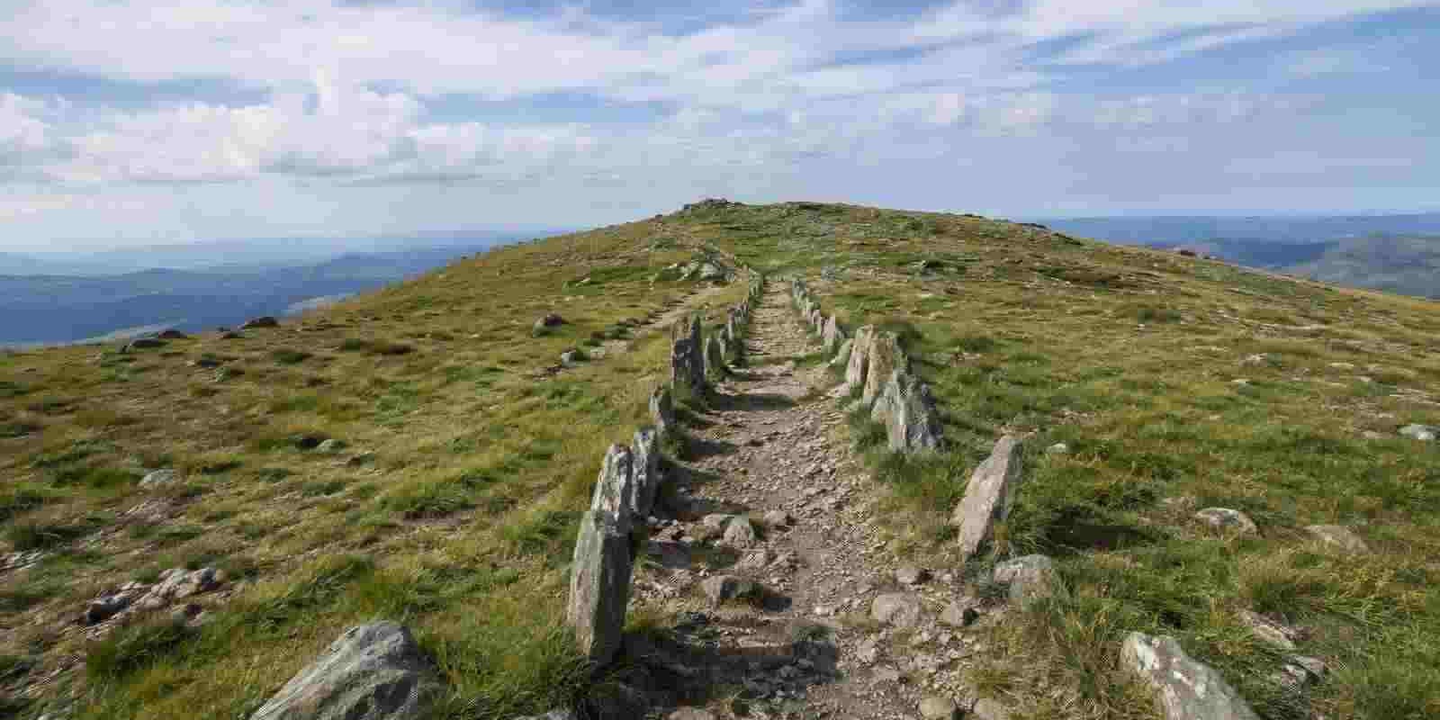 Sentier balisé de dalles de pierre plantées à la verticale menant au sommet du mont Mézenc